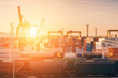 Yük taşımacılığı liman için ithalat ve ihracat kargo konteynerlerinde Vinçler ile ürünler, endüstriyel iş su nakliye ve lojistik terminalde günbatımı
