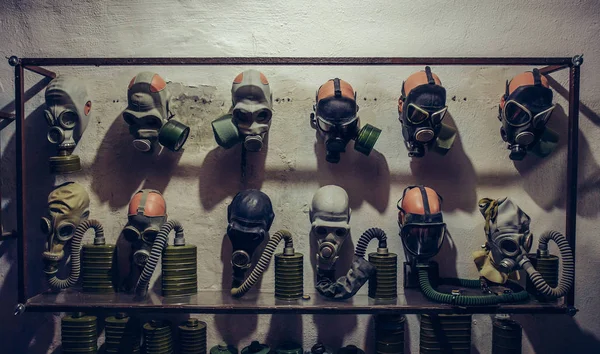 Багато старовинних газових масок на стіні в бомбовому притулку — стокове фото