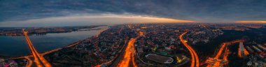 Yukarıdan gece Voronezh şehir panoraması, ışıklandırılmış yollar ve trafik, binalar, nehir ve köprüler, drone fotoğraf ile gün batımından sonra şehrin havadan görünümü