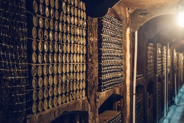 Bodega con muchas botellas polvorientas de alcohol, almacén subterráneo para fermentación y almacenamiento de vino — Foto de Stock