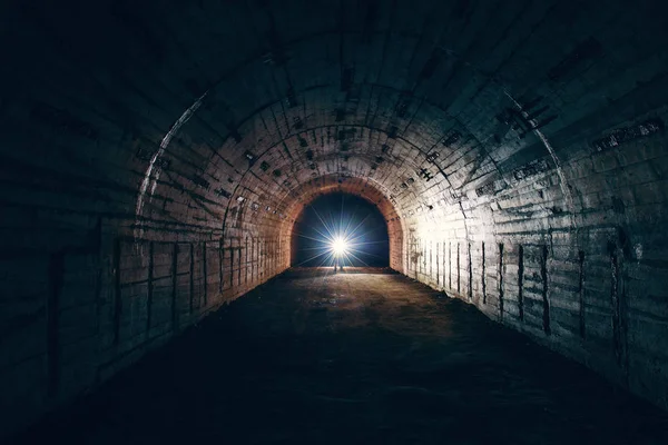 Dark creepy abandoned underground tunnel or vault corridor in bomb shelter and man with flashlight, abstract light in end concept — Stock Photo, Image