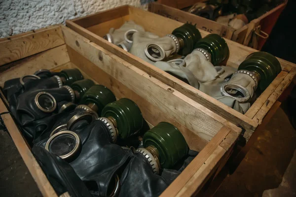 Wooden box with old vintage gas masks, anti pollution protection, close up