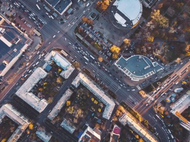 Şehir merkezindeki yol kavşakları ve kavşaklarının üst görünümü, kentsel binalar arasında araç trafiği, modern Avrupa ulaşım altyapısı, drone'dan havadan görünüm