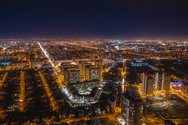 Aerial cityscape panoramic view, flight on drone above night city Voronezh with illuminated roads and high-rise buildings, toned