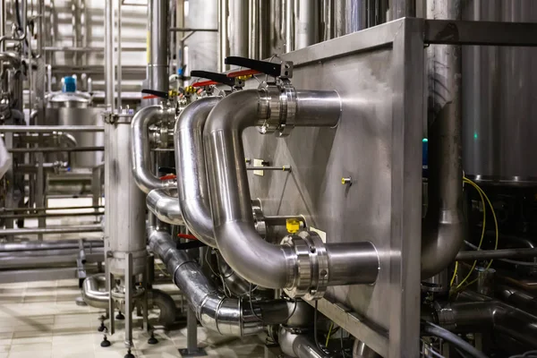 Tubos de aço inoxidável e reservatórios ou tanques, produção industrial de cerveja, tubulação de metal no processo de fermentação e destilação de cervejaria como fundo industrial abstrato — Fotografia de Stock