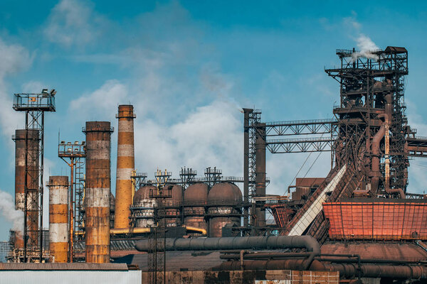 Metallurgical factory with chimneys and smog. Industrial plant for steelworks, ironworks or metalworks as heavy industry background.