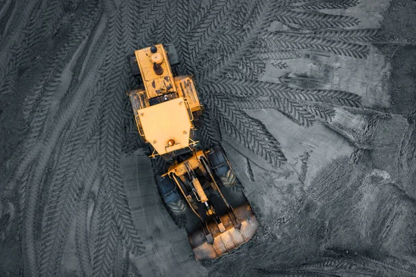 Yellow excavator or bulldozer in coal open cast mining quarry, industrial extraction of minerals, aerial top view — Stock Photo, Image