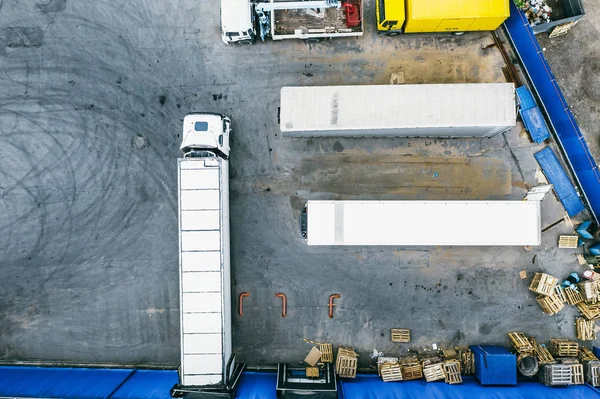 Аэрофото грузовых автомобилей на промышленном складе или логистическом центре, ожидающих погрузки грузов, вид сверху — стоковое фото