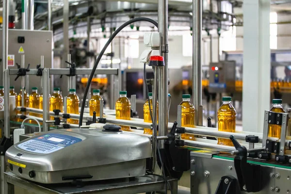 Línea de producción de jugo en planta de bebidas o fábrica, equipo industrial informatizado moderno. Jugo fresco en botellas de plástico — Foto de Stock