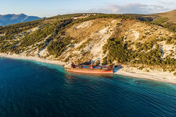 Aerial view of ship run aground on sea coast, shipwreck after storm