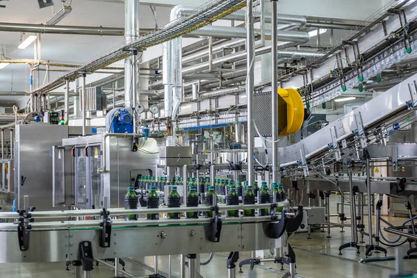 Förderband oder Linie in Getränkeindustrie mit moderner automatisierter industrieller Maschinenausrüstung. Plastikflaschen mit frischem Bio-Saft im Fabrikinneren — Stockfoto