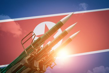 Ballistic missiles or rockets at North Korea flag background. Weapons of mass destruction and threat of nuclear war clipart