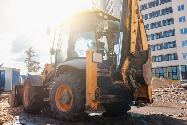 Wheel loader exkavator atau bulldozer di lokasi konstruksi bangunan baru di bawah sinar matahari — Stok Foto
