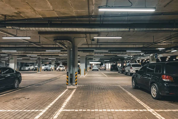 Parking souterrain éclairé avec beaucoup de véhicules — Photo
