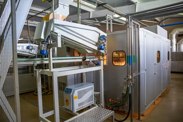 Máquina de soplado de botellas de plástico en fábrica. Fabricación de forma a partir de PET preforma por calentamiento —  Fotos de Stock