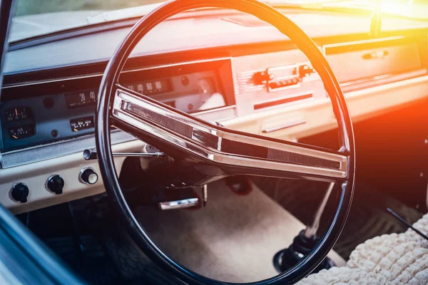 Intérieur de voiture classique rétro ou vintage avec volant au coucher du soleil, gros plan — Photo