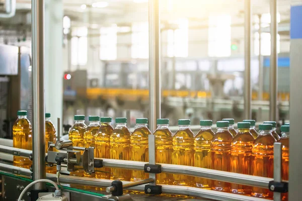 Cinta transportadora con jugo en botellas de plástico en planta de bebidas o fábrica —  Fotos de Stock