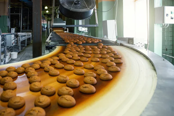 Produksi roti dengan kue manis pada mesin konveyor belt di bengkel pabrik permen, produksi makanan industri — Stok Foto