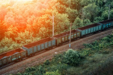 Yük treni hızlı, demiryolu vagonları güneş ışığında. Ulaşım, demiryolu