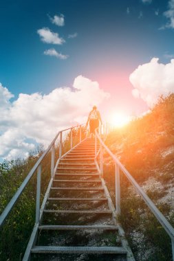 Genç kız turist tırmanıyor veya dağ tepe, yaz seyahat macera kavramı üzerinde büyük çelik merdiven kadar gider