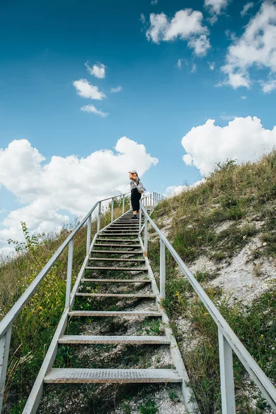 Genç kız turist tırmanıyor veya dağ tepe, yaz seyahat macera kavramı üzerinde büyük çelik merdiven kadar gider — Stok fotoğraf