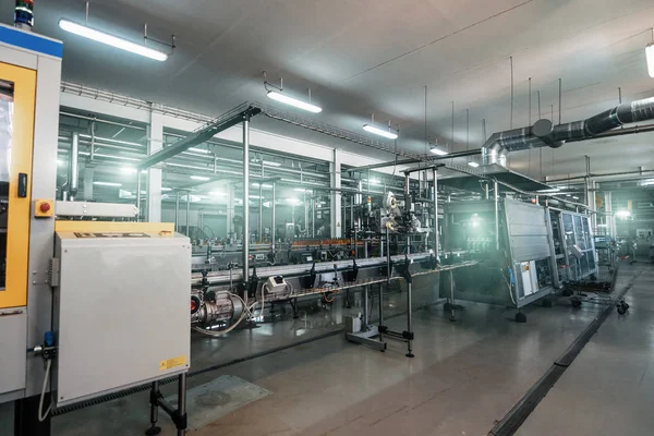 Moderna fábrica de bebidas o interior de la planta con equipos de producción de alimentos industriales especiales. Cinta transportadora automatizada —  Fotos de Stock