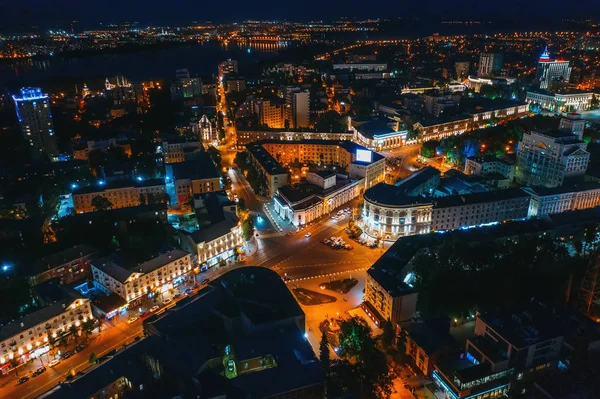 Vista aérea de la ciudad nocturna con intersección de transporte o cruce, tráfico de automóviles y calles iluminadas con edificios, disparo de dron — Foto de Stock