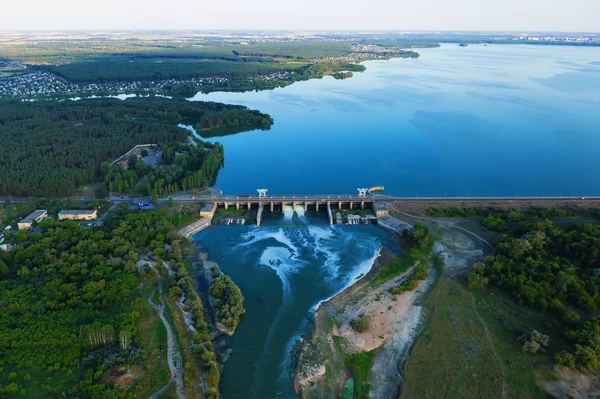Воздушный панорамный вид на бетонную плотину на водохранилище с текущей водой, гидроэлектростанцию, дронный выстрел — стоковое фото