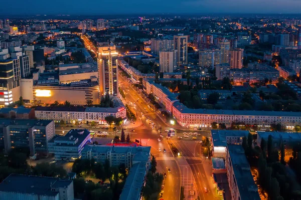 Night City Voronezh centro de la ciudad o el centro de panorama desde arriba con la intersección de carreteras iluminadas, el tráfico de coches, modernos edificios de negocios y residenciales, vista aérea — Foto de Stock