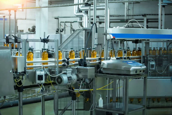 Correia transportadora automática da linha de produção de suco na fábrica ou fábrica de bebidas, equipamentos industriais computadorizados modernos. Sumo fresco em garrafas de plástico — Fotografia de Stock