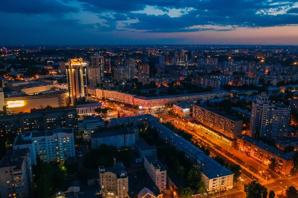Widok z lotu ptaka nocą z podświetlanymi drogami, ruchem samochodowym i różnymi budynkami — Zdjęcie stockowe