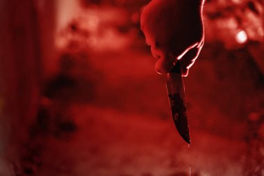 Erkek katil el kırmızı ışıklı karanlık korkunç evde kan bıçak tutan