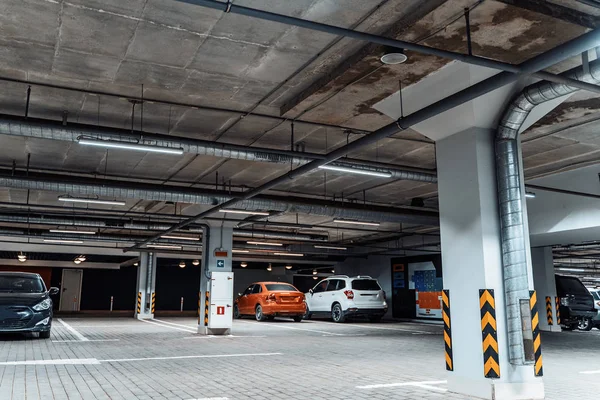 Parking souterrain éclairé intérieur sous le centre commercial moderne avec des véhicules — Photo