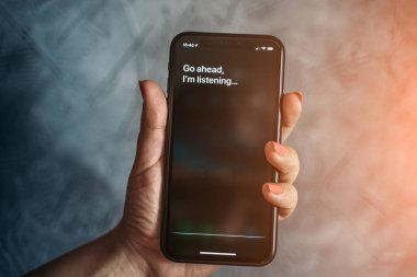 Moskova, Rusya - Circa Ağustos 2019 : Iphone Xr kadın elinde ve sesli Apple dijital asistan Siri ve akıllı telefon ekranında metin tarafından aktive: Devam edin, dinliyorum..