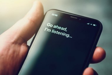 Moskova, Rusya - Circa Ağustos 2019 : Erkek elinde Iphone Xr ve sesli Apple dijital asistanı Siri ve akıllı telefon ekranında metin tarafından aktive: Devam edin, dinliyorum..
