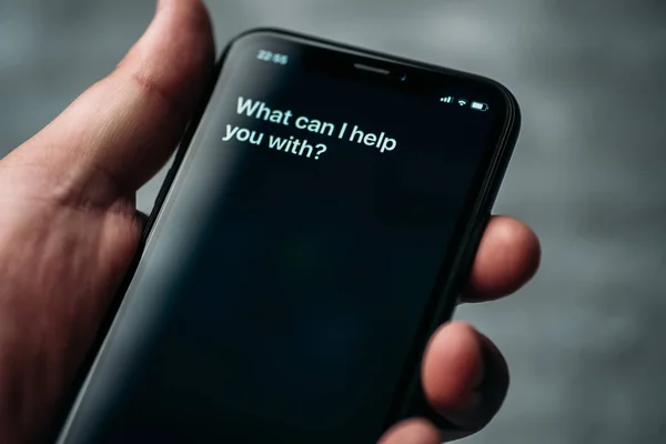 Moscou, Rússia - Circa agosto 2019: Siri - Assistente digital de voz da Apple ativado por voz na mão masculina e texto na tela do iPhone: Em que posso ajudá-lo? Modo de voz de interação com tphone — Fotografia de Stock