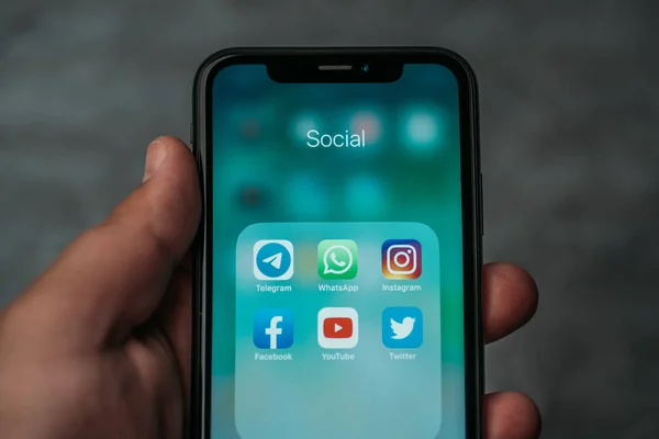 Moscou, Russie - Vers août 2019 : Iphone XR à la main masculine avec des icônes de l'application populaire de médias sociaux ou des applications à l'écran pour le mode de vie de l'utilisation des smartphones — Photo