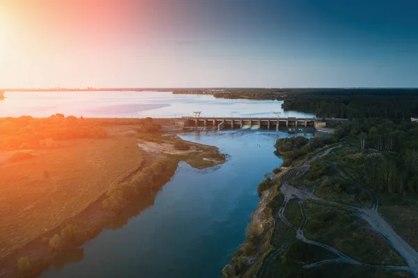 Vista aérea da barragem no reservatório com água corrente ao pôr do sol, central hidroeléctrica, foto drone — Fotografia de Stock
