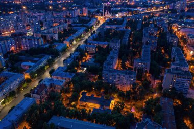 Işıklı yollar, araba trafiği ve farklı binalar, drone çekim ile gece şehir havadan görünümü