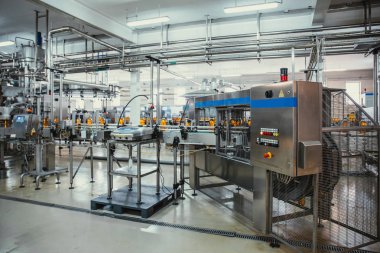 Modern içecek fabrikasında veya fabrika üretiminde otomatik konveyör hattı veya kayış üzerinde meyve suyu ile plastik şişeler