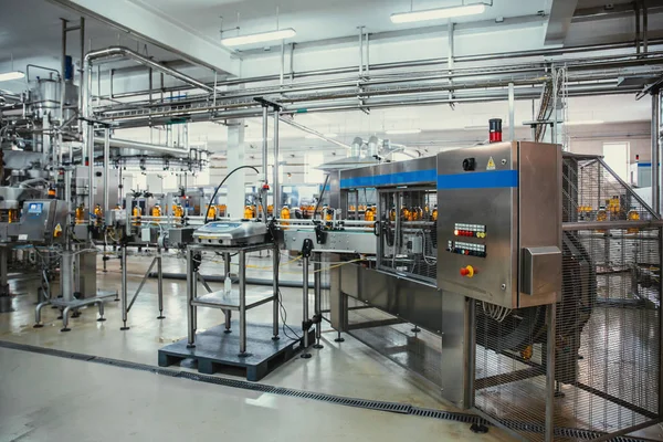 Botellas de plástico con jugo en la línea transportadora automatizada o en la banda en la moderna planta de bebidas o producción en fábrica —  Fotos de Stock