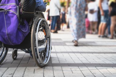 Tekerlekli sandalye sokakta birçok kişinin bulanık arka plan üzerinde engelli adam ile. Engelli ler ve toplum kavramı sorunu