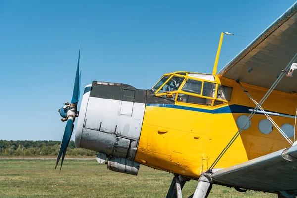 Вінтажний літак на зеленій траві та синьому фоні неба на сонячному світлі. Старий ретро літак — стокове фото