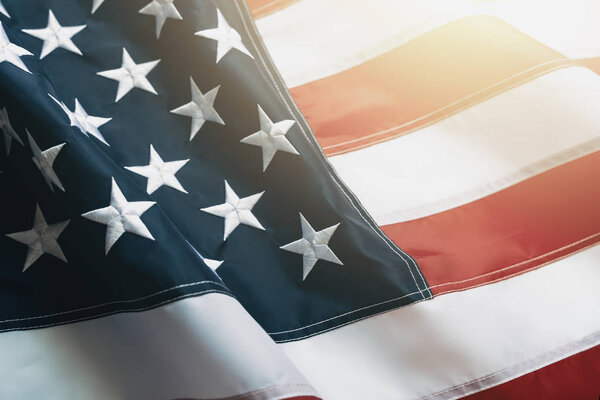 USA flag background. Waving American flag in sunlight flare, close up