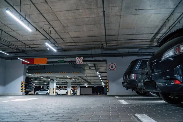 Parking souterrain éclairé intérieur sous le centre commercial moderne avec des véhicules — Photo