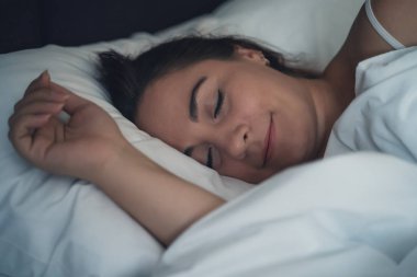 Genç güzel kız veya kadın gece büyük yatakta yalnız uyku