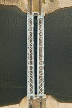 Nehir üzerindeki çelik demiryolu köprüsünün havadan yukarıdan aşağıya görünümü, drone fotoğrafı, dikey görüntü