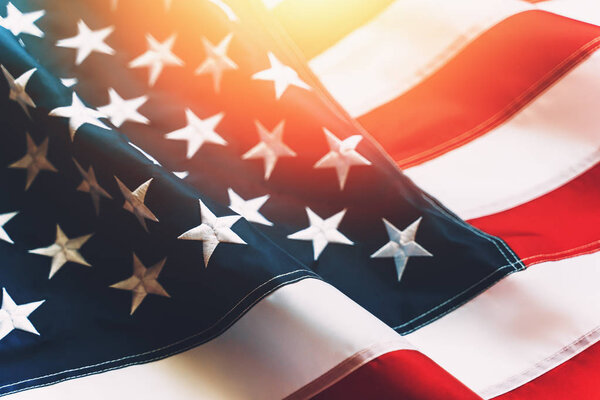 USA flag background. Waving American flag in sunlight flare, close up