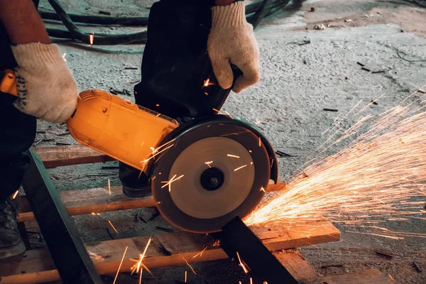 El trabajador corta el metal con la hoja circular de la amoladora en el sitio de construcción, de cerca — Foto de Stock