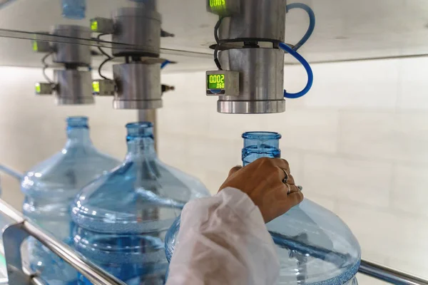 Empty plastic bottles or gallons on conveyor belt machinery equipment for checking plastic integrity and hardness in pure water production factory